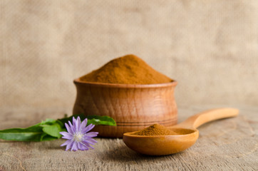 Blue chicory flower and full wooden spoon of powder  instant chi © Soyka