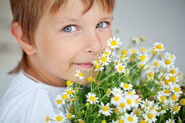 happy little boy with camomile bouquet 