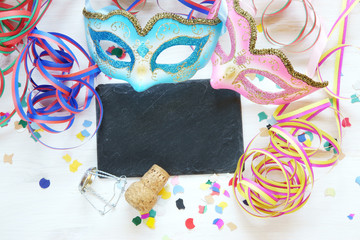 Karneval, Fasching, Fastnacht - Tafel mit Copyspace und Luftschlangen, Konfetti, Masken, Sektkorken auf weissem Brett