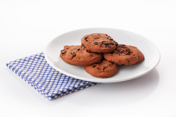 Pile of homemade chocolate chip cookies on white ceramic plate
