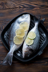 Above view of a grill pan with two uncooked dorados, studio shot