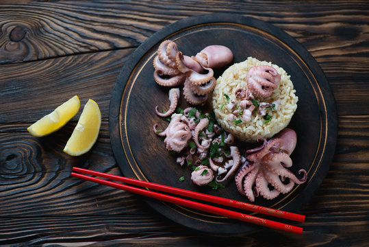 Octopuses with brown rice served on a wooden cutting board
