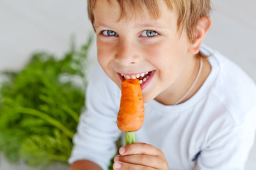 A boy are eating fresh carrot 
