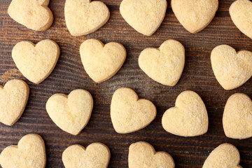 tasty cookies in the shape of a heart on a brown wooden table