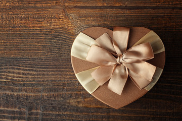 box in the shape of heart with bow on wooden table