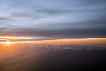 Fototapeta na wymiar Morning Sun & Cloudy sky from airplane Through window onto jet engine - flying view (window airplane) 