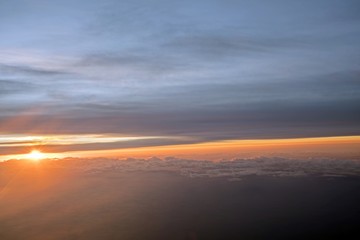 Fototapeta na wymiar Morning Sun & Cloudy sky from airplane Through window onto jet engine - flying view (window airplane) 