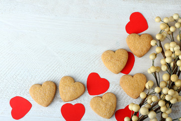 Obraz premium cookies in the shape of a heart and a paper heart on wooden table