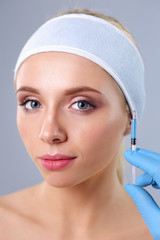Cosmetic injection on the pretty woman face. Isolated on gray background