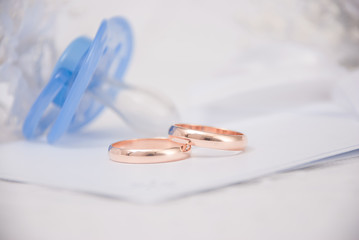 The wedding invitation with wedding rings and a bouquet of the bride on a white background