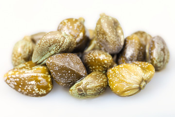 several green pickled capers on white