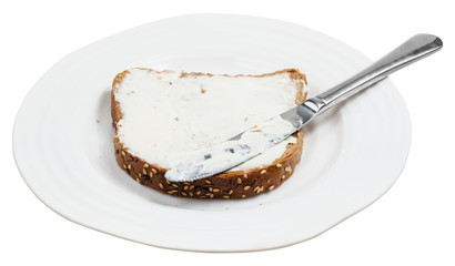 grain bread with Cheese spread and knife on plate