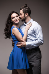 young happy smiling attractive couple, isolated on grey background