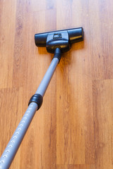 above view vacuuming of parquet by vacuum cleaner