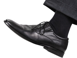 male left leg in black shoe takes a step