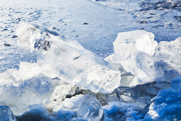 Fototapeta na wymiar ice blocks on the edge of ice-hole in frozen lake