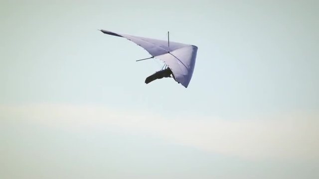 Hang glider in the air turning right then left.
