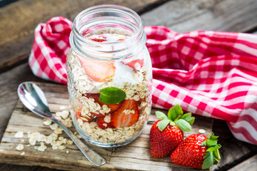 Healthy oatmeal with fresh strawberries in a mason jar