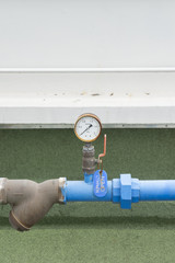Closeup of manometer, measuring gas pressure. Pipes and valves o