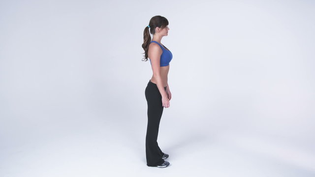 Right side view, full body of a woman in gym clothes putting hands on hips