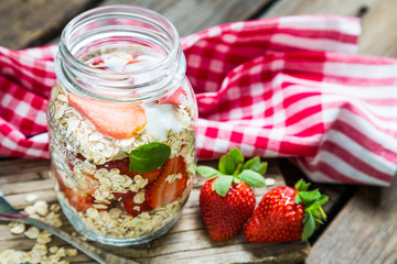 Healthy oatmeal with fresh strawberries in a mason jar