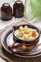 Homemade cauliflower soup in a brown bowl.