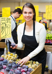 Positive smiling  woman selling fresh fruit