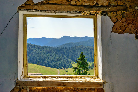Fototapeta mountain landscape through the window of an abandoned house