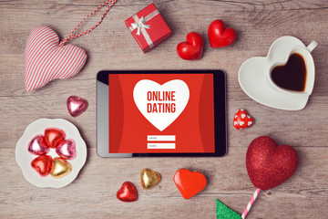 Online dating cocept with digital tablet mock up and heart chocolates. Valentine's day romantic celebration. View from above - obrazy, fototapety, plakaty