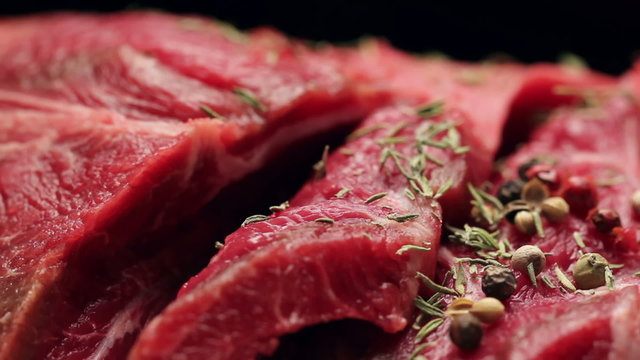 Fresh raw beef meat with peppercorns ready to grill, rotating