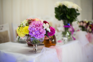 Beautiful freshly cut flowers in a glass vase on wedding recepti