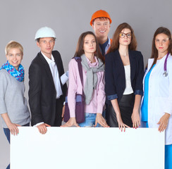 Portrait of smiling people with various occupations holding blank billboard 