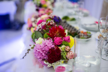Obraz na płótnie Canvas Beautiful freshly cut flowers in a glass vase on wedding recepti