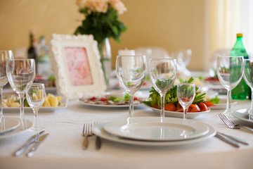 Elegantly catered wedding reception table: glasses, plates and s