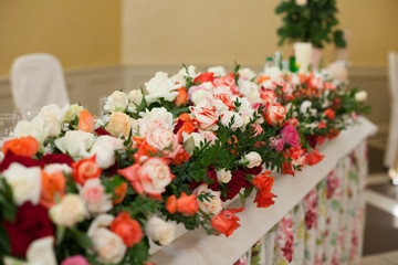 Beautiful and elegant wedding reception table covered with flowe