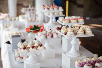 Wedding reception dessert table with delicious decorated white c