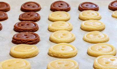 Raw dough. Yellow and brown cookies buttons. Cooking.