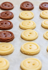 Raw dough. Yellow and brown cookies buttons. Cooking.