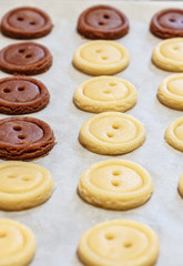 Raw dough. Yellow and brown cookies buttons. Cooking.
