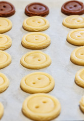 Raw dough. Yellow and brown cookies buttons. Cooking.