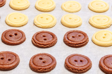 Obraz premium Raw dough. Yellow and brown cookies buttons. Cooking.