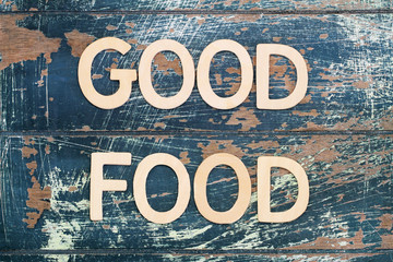 Good food written with wooden letters on rustic surface
