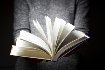 Book in woman's hands in gesture of giving