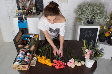 Florist making bright orange and pink bouquet