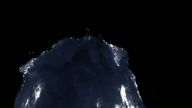 A blacklit verticle fountain splashes against a black backround.