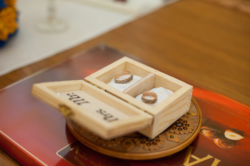 Two stylish golden engraved rings in wooden box closeup