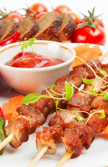 Shish kebab with herbs on a white plate