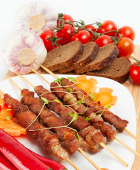Shish kebab with herbs on a white plate