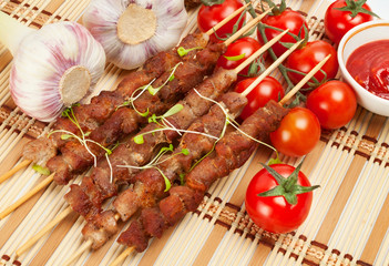 Pork skewers with cherry tomatoes and garlic