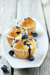 Tasty blueberry muffins on a grey wooden background